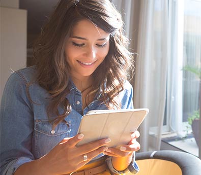 Smiling Woman Looking at Tablet Smiling Woman Looking at Tablet
