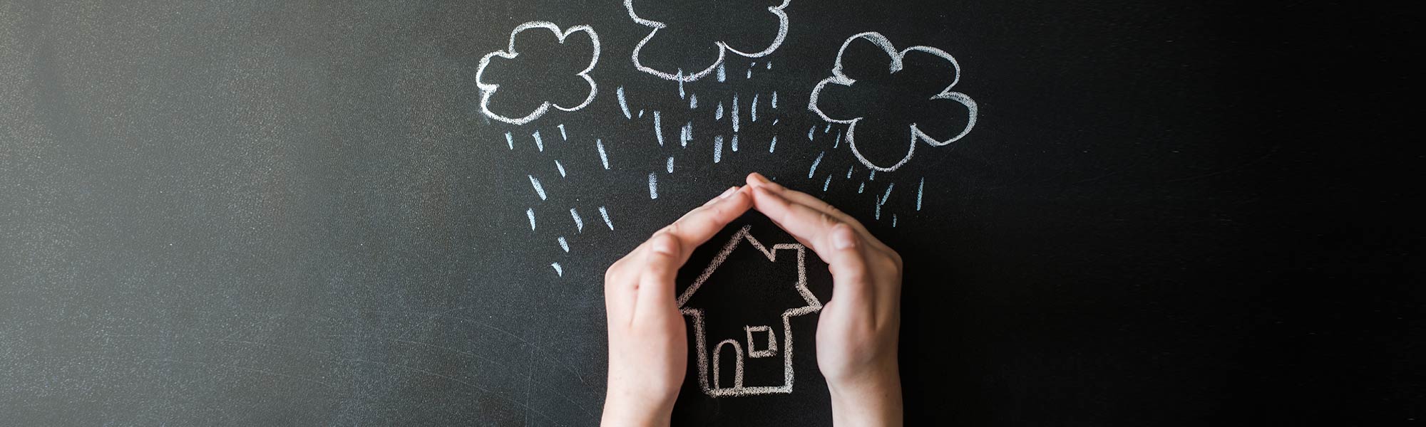 Child's Hands Protecting Chalk Drawn of House from Storm
